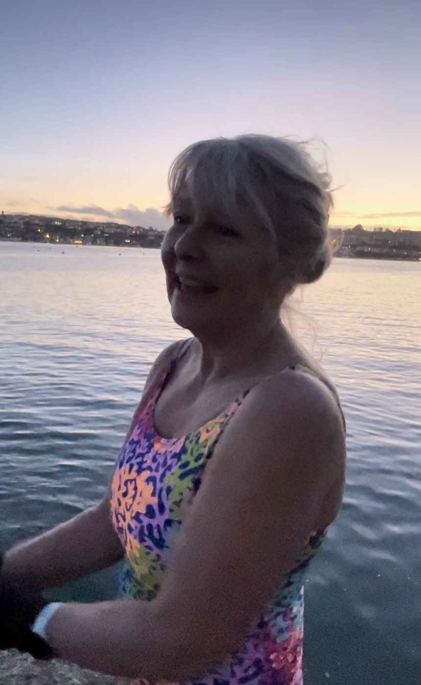 Ruth smiling at dusk after a swim