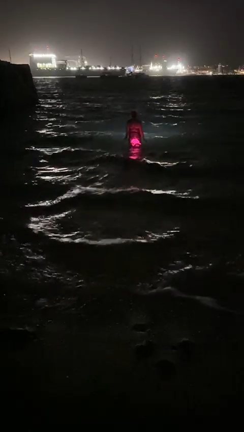 A night swim, lit up pink
