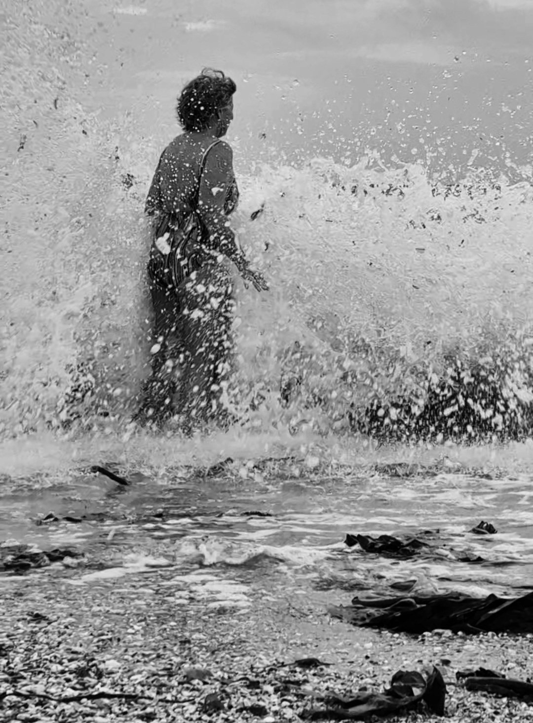 A wave crashing over Ruth mid-swim