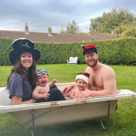 A family in a garden bathtub in hats