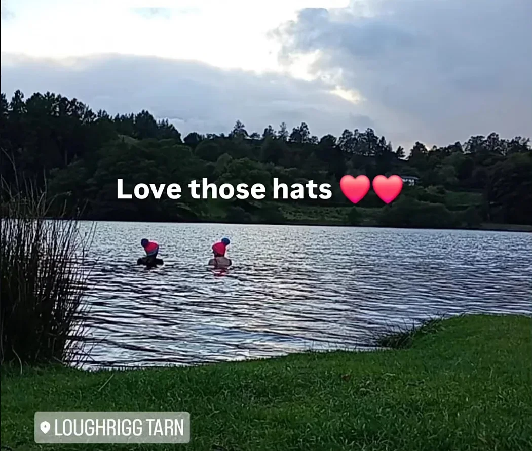 Two swimmers in bobble hats in Loughrigg Tarn